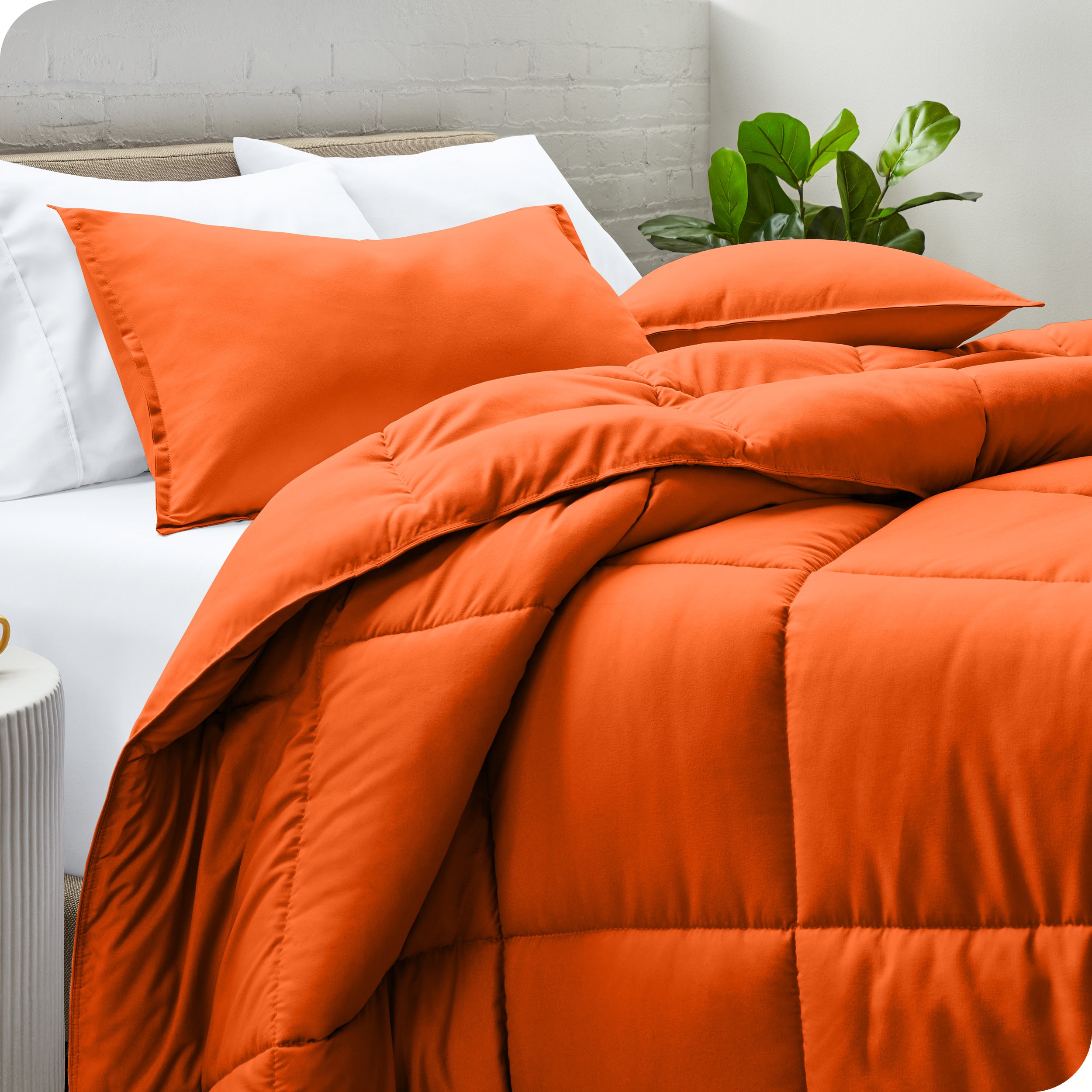 A side view of a modern bed with a comforter set and pillows on the bed