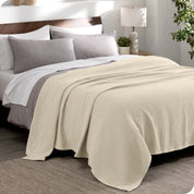 A cotton waffle blanket draped over a bed