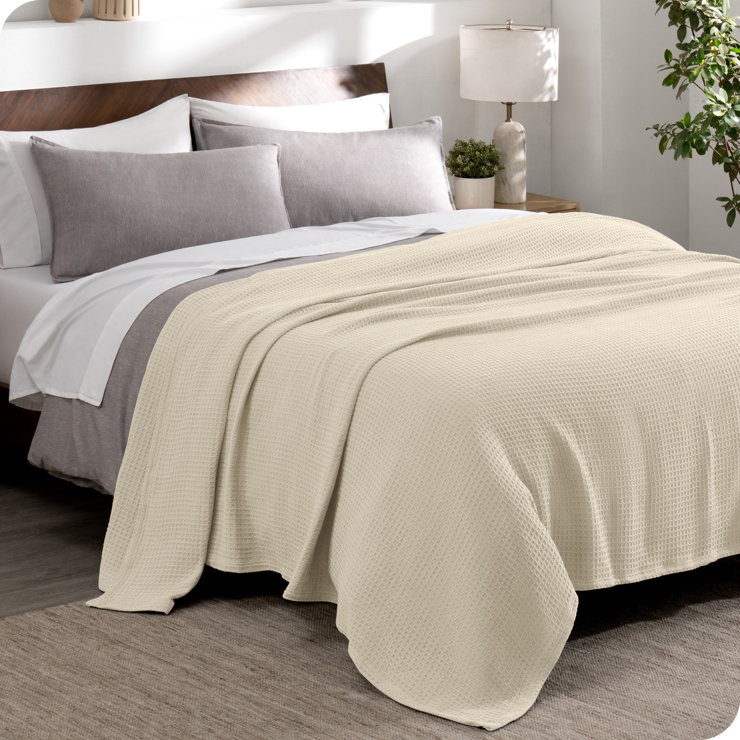A cotton waffle blanket draped over a bed