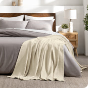 A cotton waffle blanket on the corner of a bed