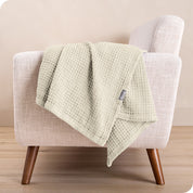A cotton blanket on the arm of a chair