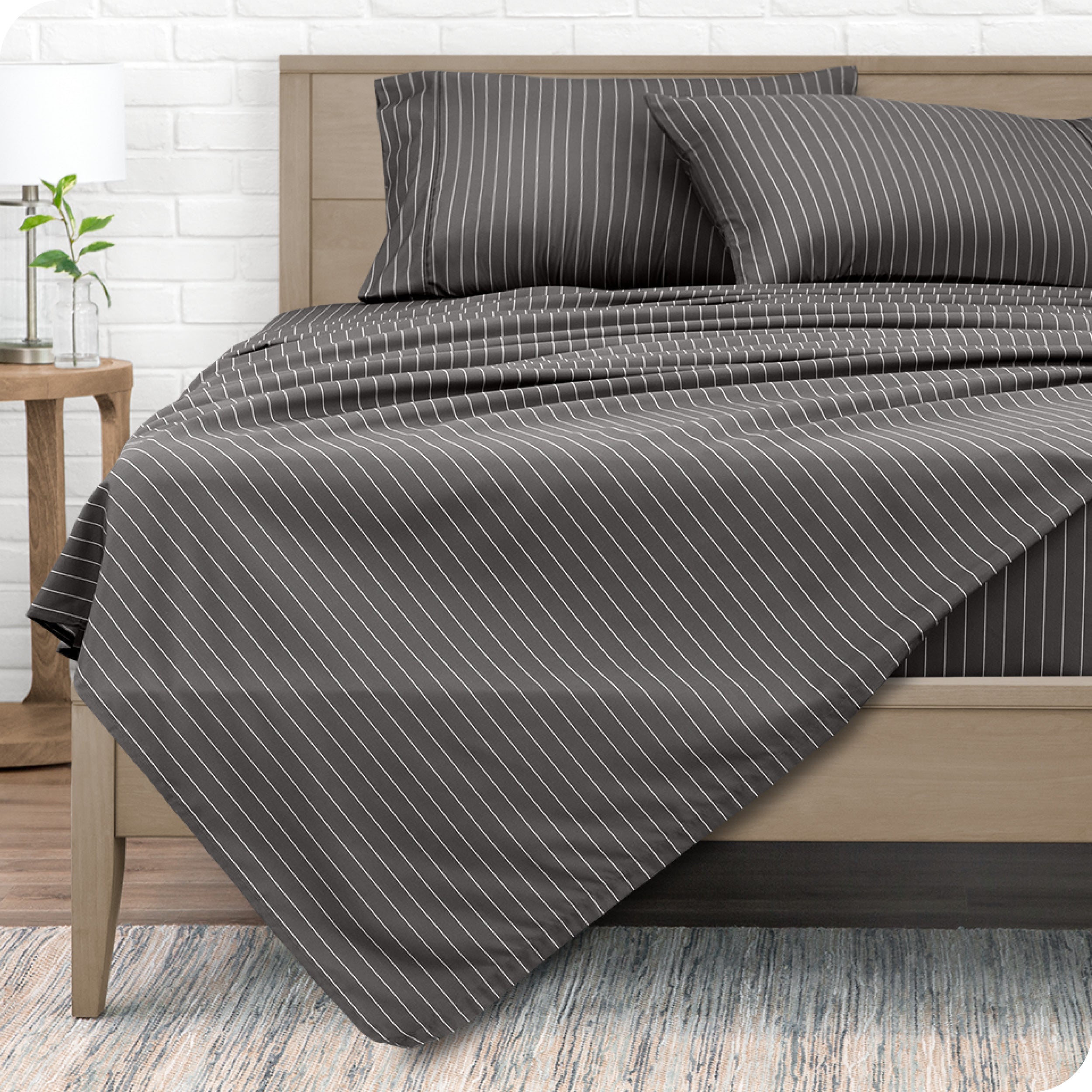 View from the end of a modern bed made with a microfiber sheet set with a modern print.