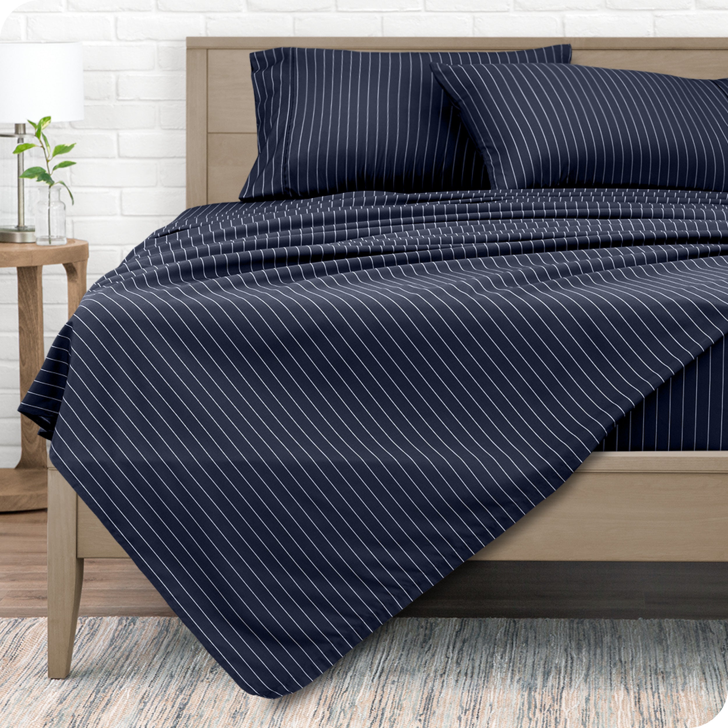 View from the end of a modern bed made with a microfiber sheet set with a modern print.