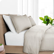 A diagonal view of a modern bed with a printed duvet cover on it.