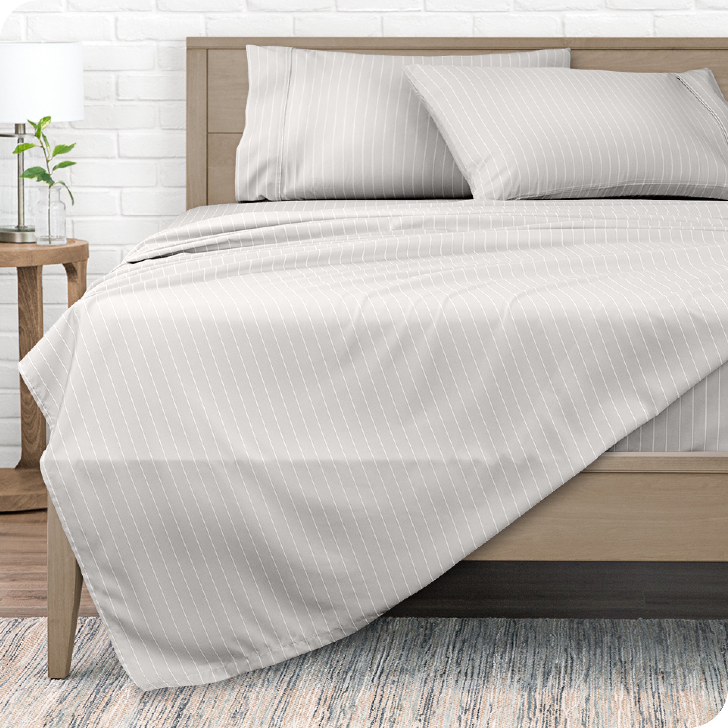 View from the end of a modern bed made with a microfiber sheet set with a modern print.