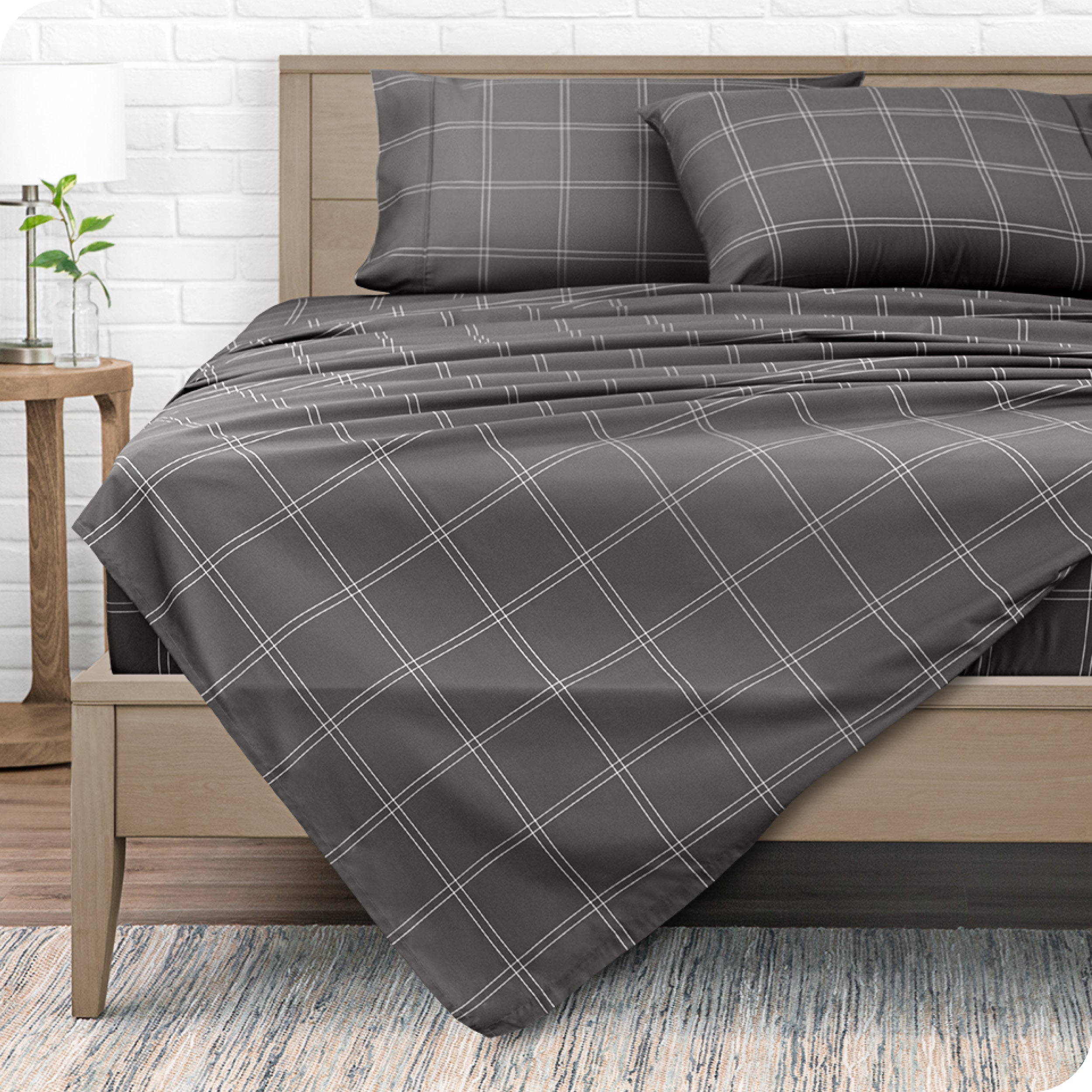 View from the end of a modern bed made with a microfiber sheet set with a modern print.
