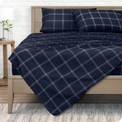 View from the end of a modern bed made with a microfiber sheet set with a modern print.