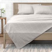 View from the end of a modern bed made with a microfiber sheet set with a modern print.