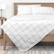 View from the end of a modern bed made with a microfiber sheet set with a modern print.
