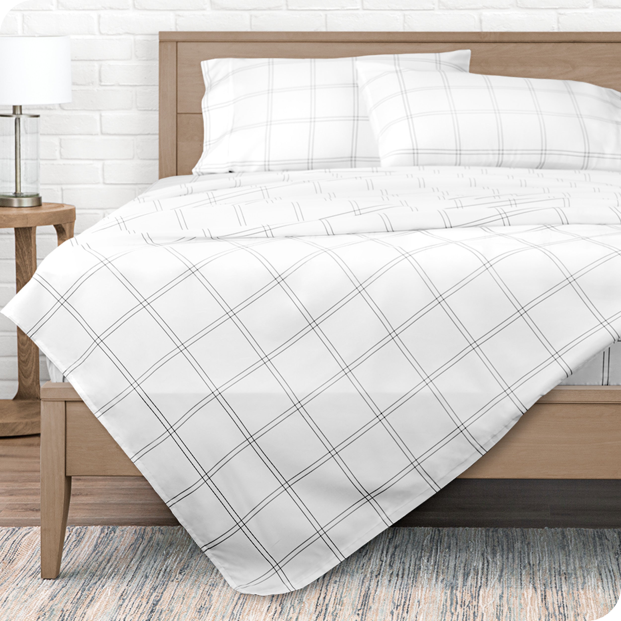 View from the end of a modern bed made with a microfiber sheet set with a modern print.