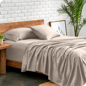 Microfiber sheets and matching pillowcases on a bed next to a large plant