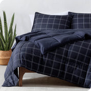 Printed comforter set on a bed next to a large plant