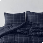 A printed comforter and matching pillow shams on a bed