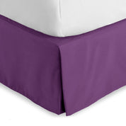 The corner of a bed skirt on a bed frame