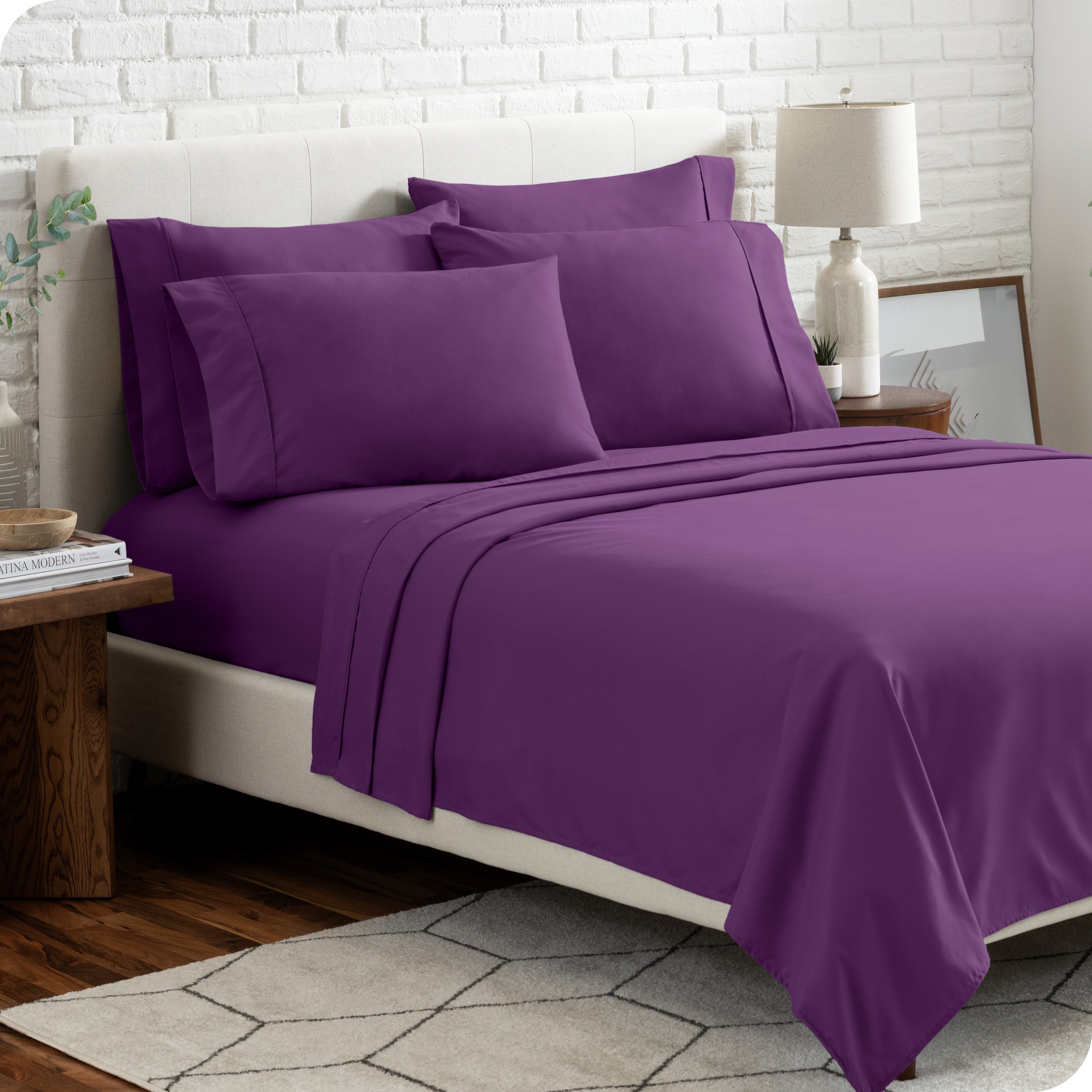 A bedroom setting with a bed made with the microfiber bed sheets and four pillows.