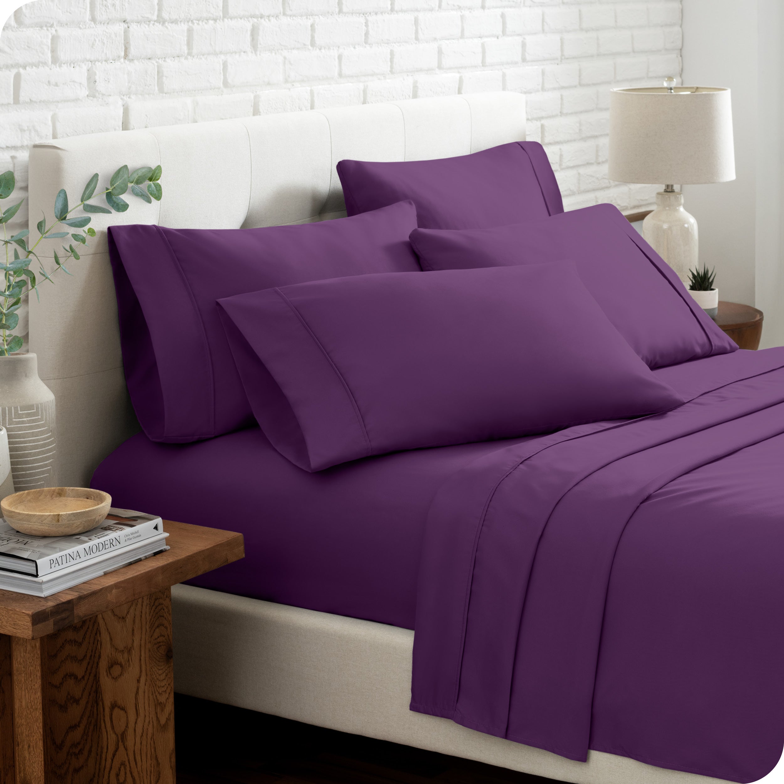 Close up of the microfiber bed sheets on a bed with four pillows.