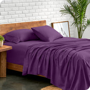 Microfiber sheets and matching pillowcases on a bed next to a large plant