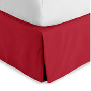 The corner of a bed skirt on a bed frame