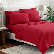 A bedroom setting with a bed made with the microfiber bed sheets and four pillows.