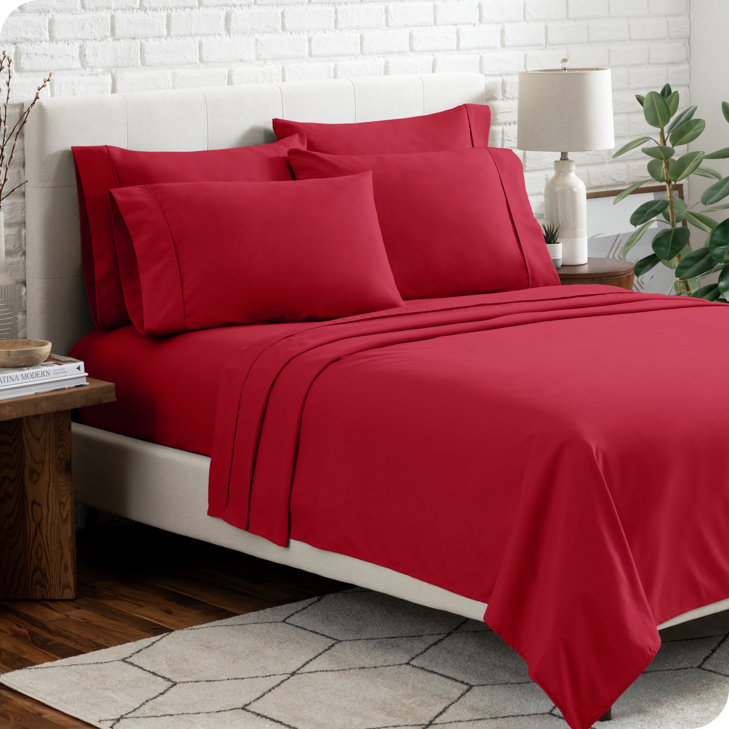 A bedroom setting with a bed made with the microfiber bed sheets and four pillows.