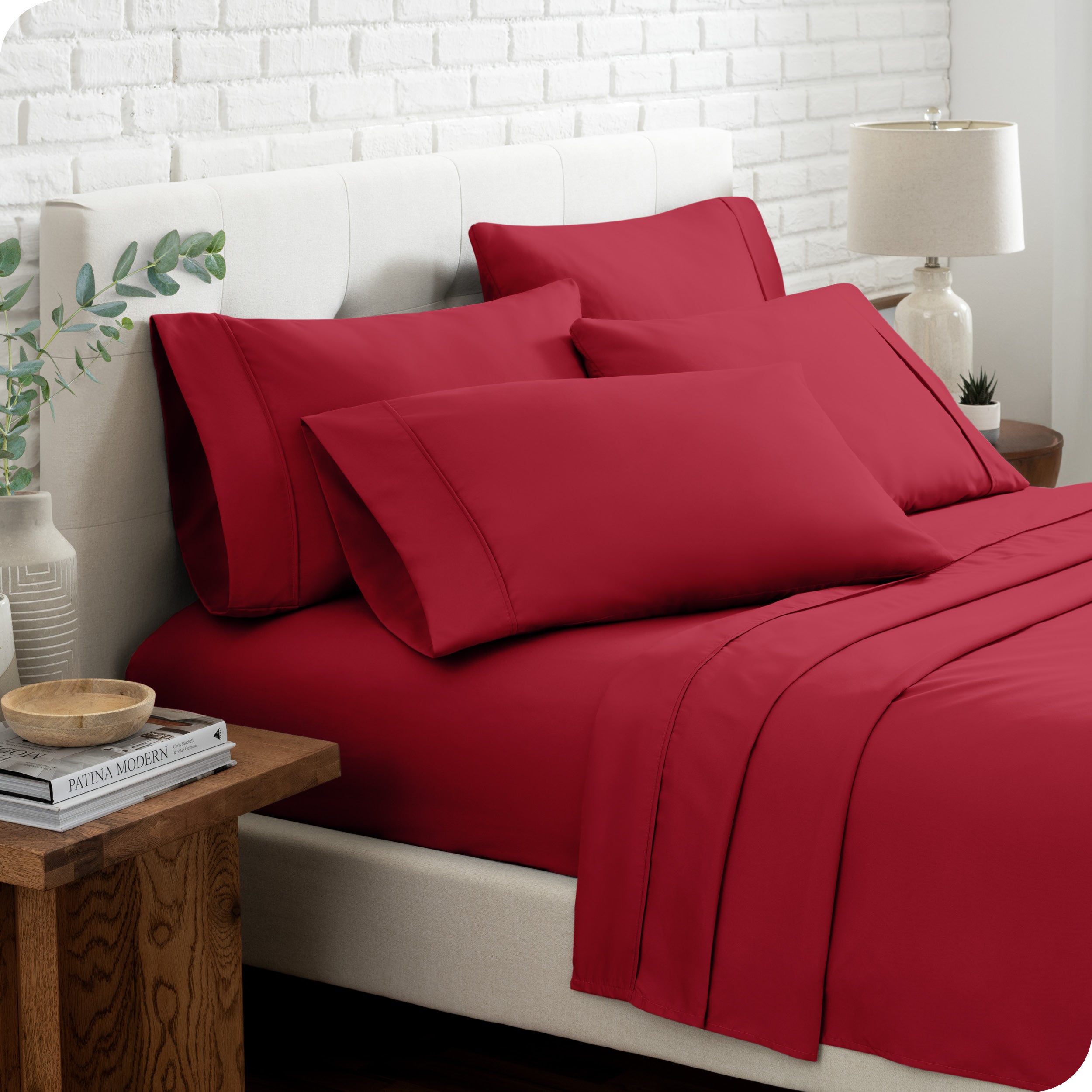 Close up of the microfiber bed sheets on a bed with four pillows.