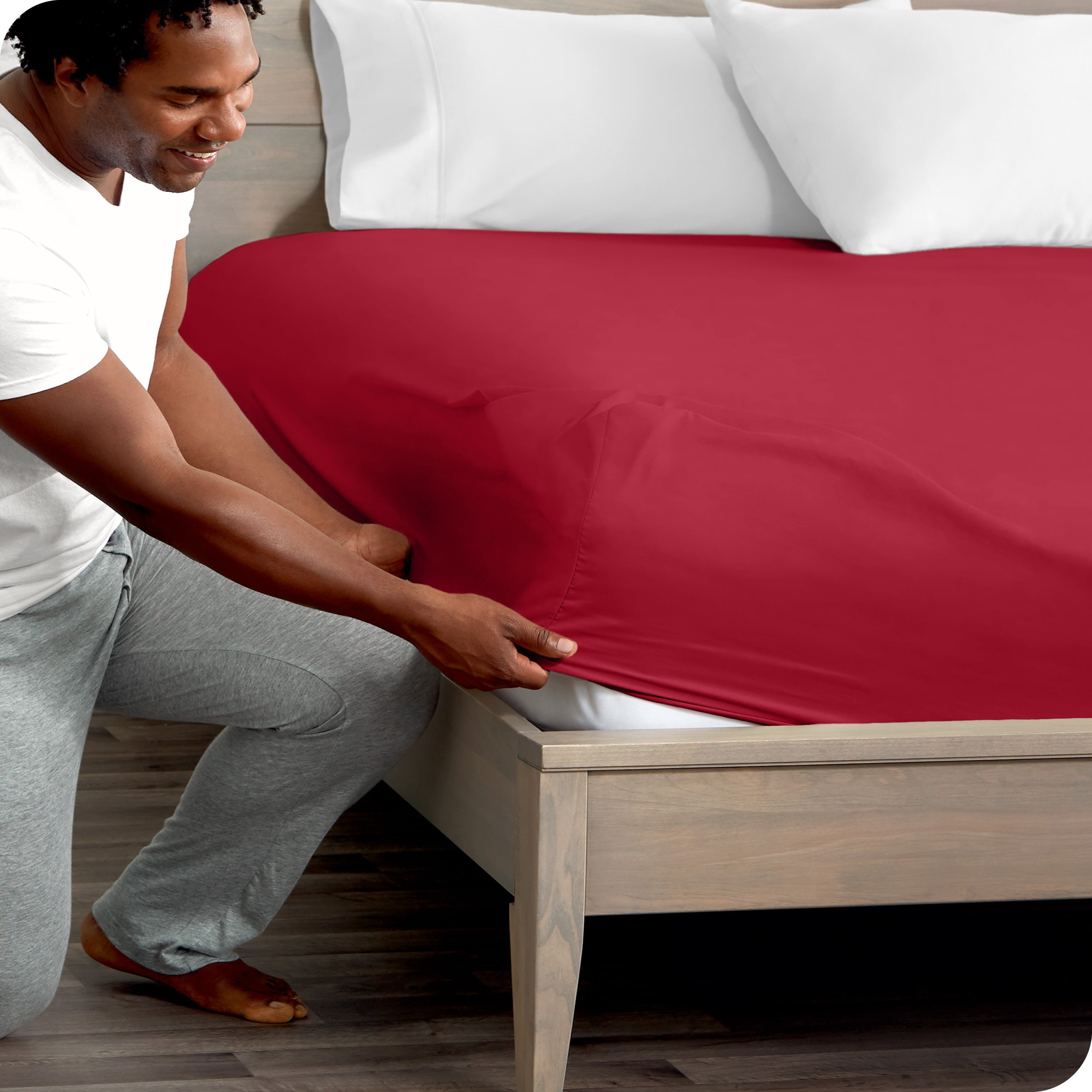A modern bed with a fitted microfiber sheet on it