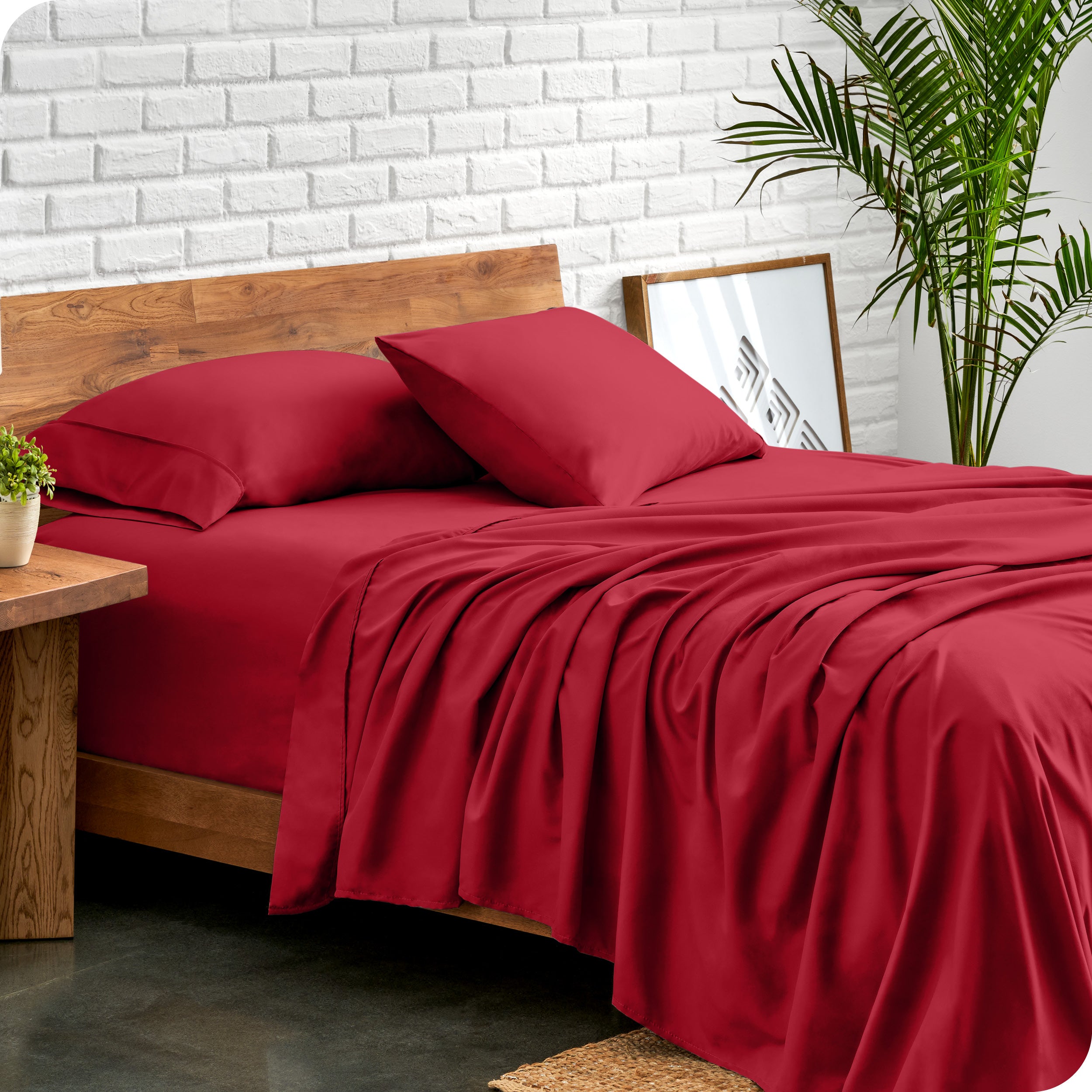 Microfiber sheets and matching pillowcases on a bed next to a large plant