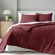 A comforter set on a bed in a bright modern room