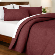 A side view of a bed made with a track stitch comforter set