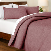 A side view of a bed made with a track stitch comforter set