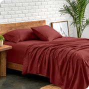 Microfiber sheets and matching pillowcases on a bed next to a large plant