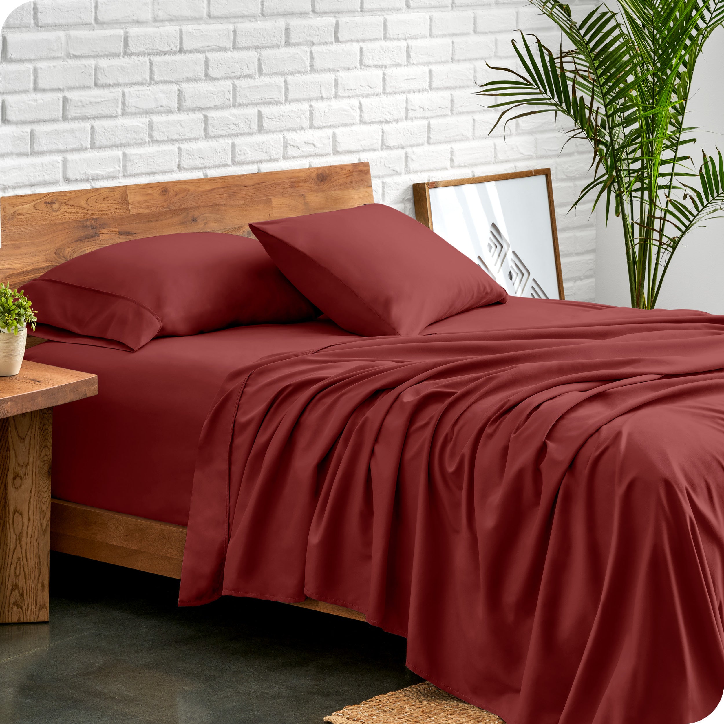 Microfiber sheets and matching pillowcases on a bed next to a large plant