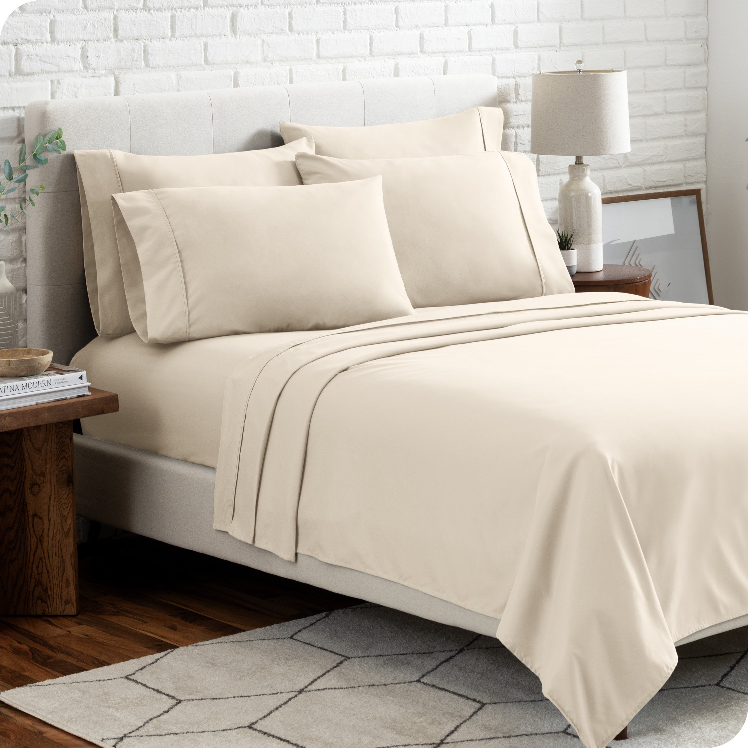 A bedroom setting with a bed made with the microfiber bed sheets and four pillows.