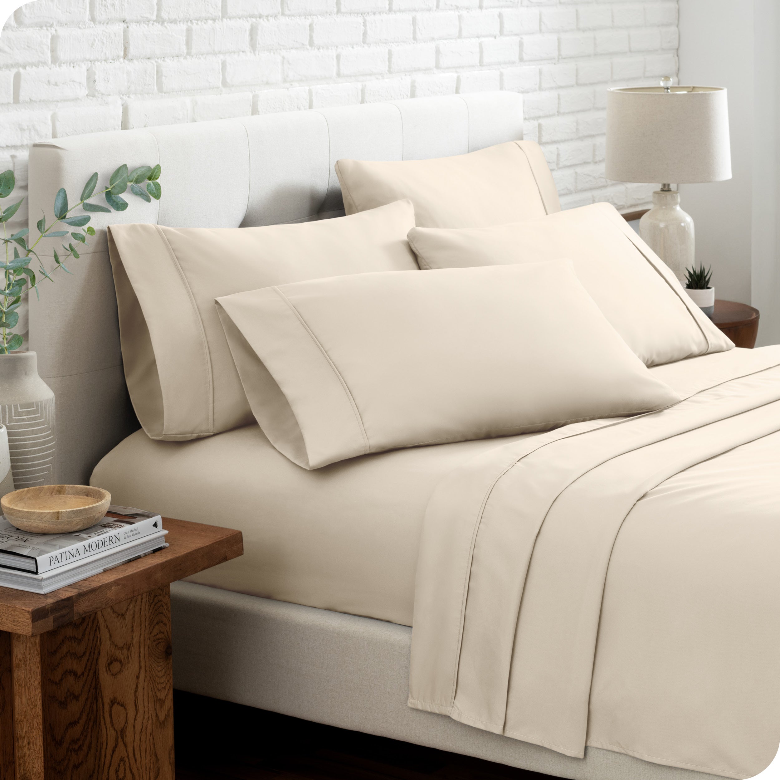 Close up of the microfiber bed sheets on a bed with four pillows.