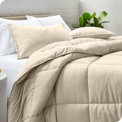 A side view of a modern bed with a comforter set and pillows on the bed