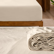 A divided image showing both the corner of a bed with organic jersey sheet and the folded sheet stacked on the bed.
