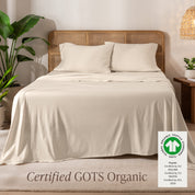 A bed in the middle of room with a set of Certified GOTS Organic Jersey Sheet Set on it.