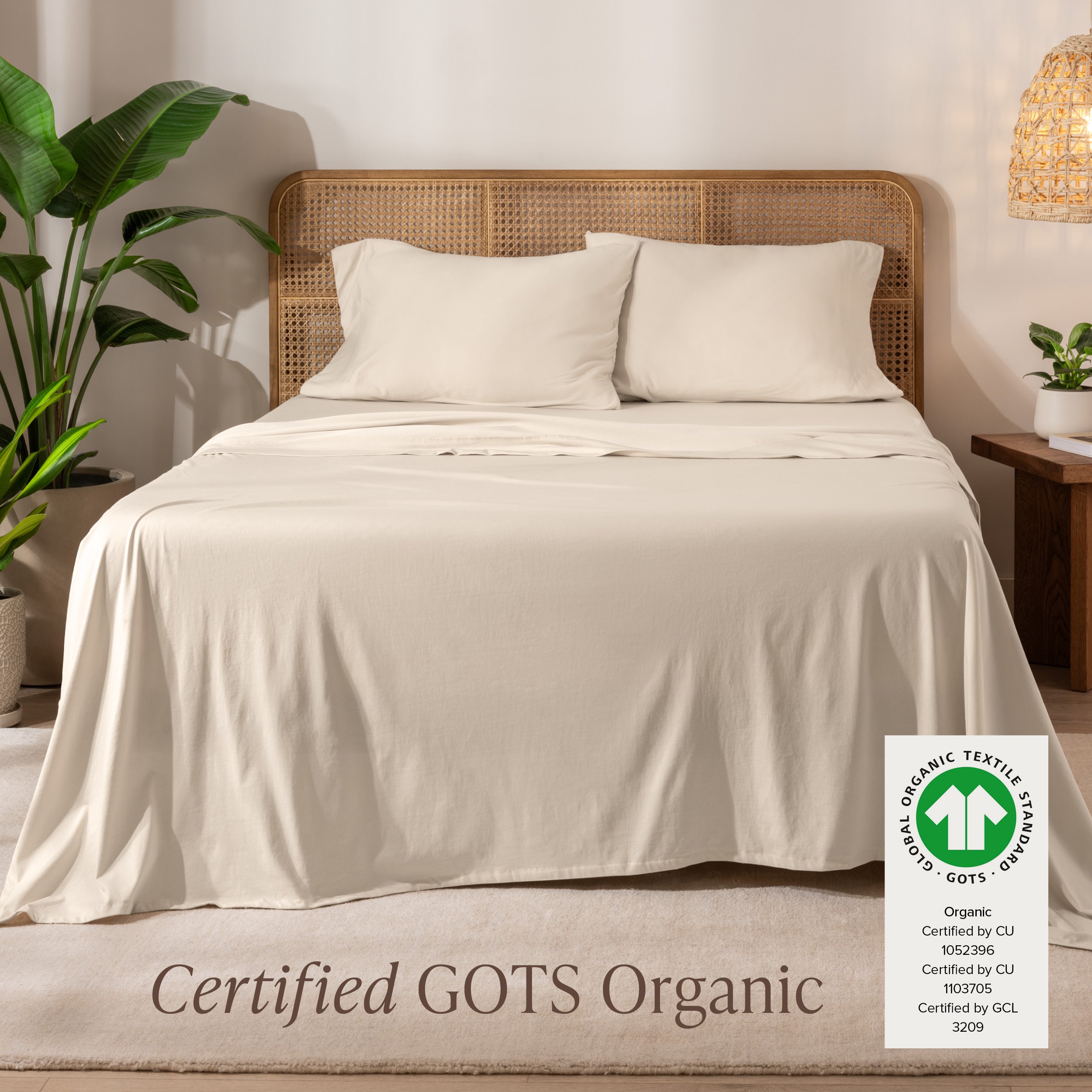 A bed in the middle of room with a set of Certified GOTS Organic Jersey Sheet Set on it.
