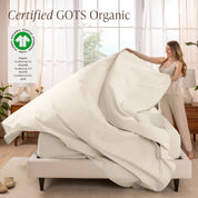 Woman putting bedding on a bed with GOTS Organic certification logo in the corner.