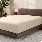 A sideview of a modern bed with a polar fleece fitted sheet on.
