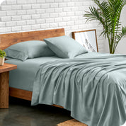 Microfiber sheets and matching pillowcases on a bed next to a large plant