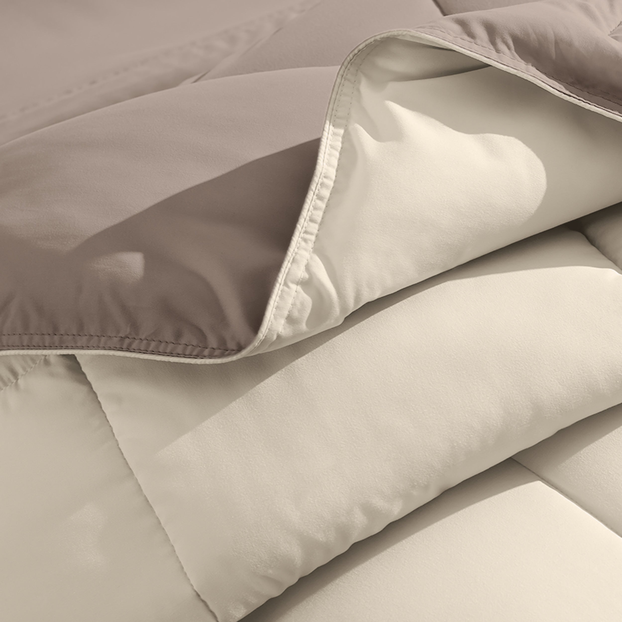 Close up of the reversible comforter showing the box stitching and the two colors