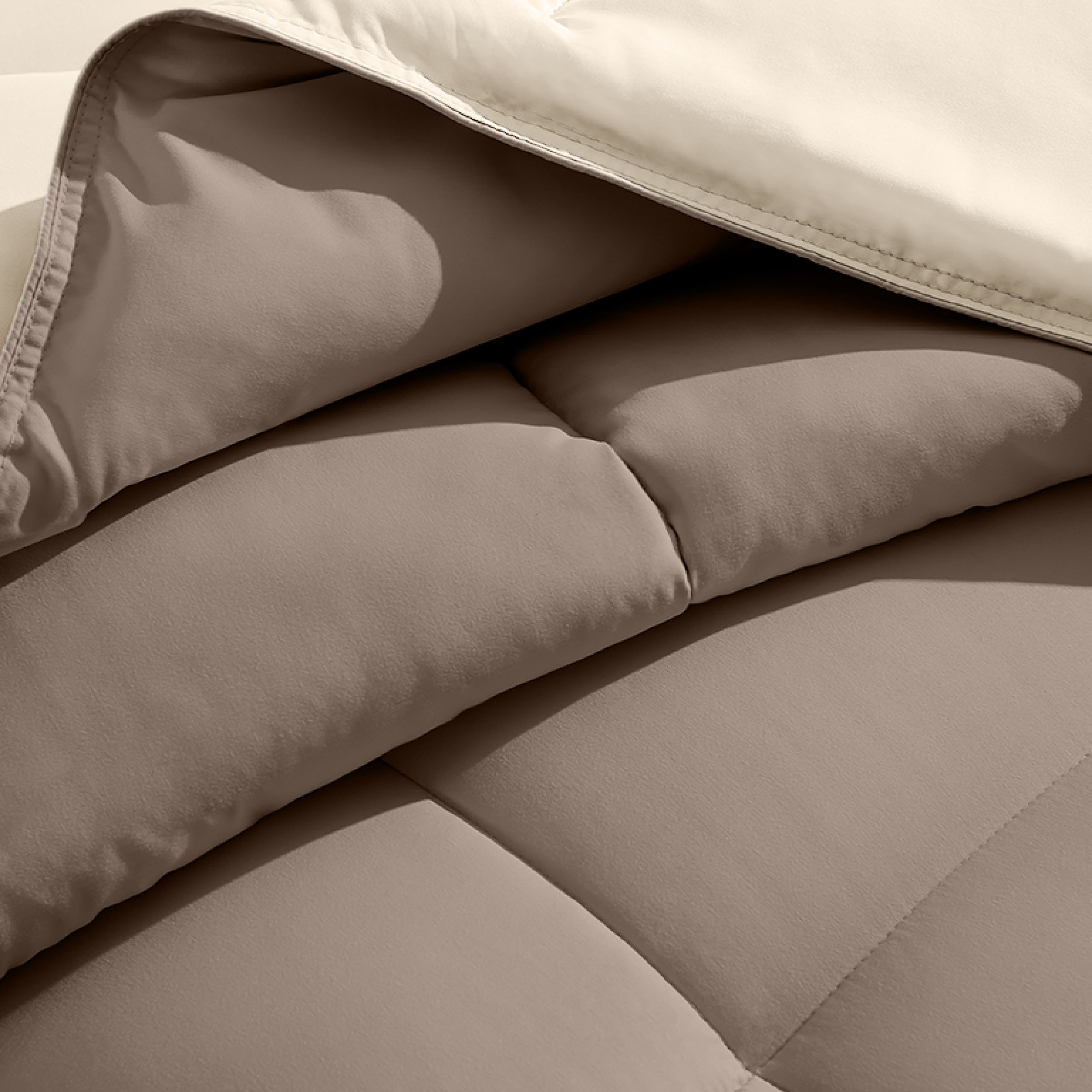Close up of the reversible comforter showing the box stitching and the two colors