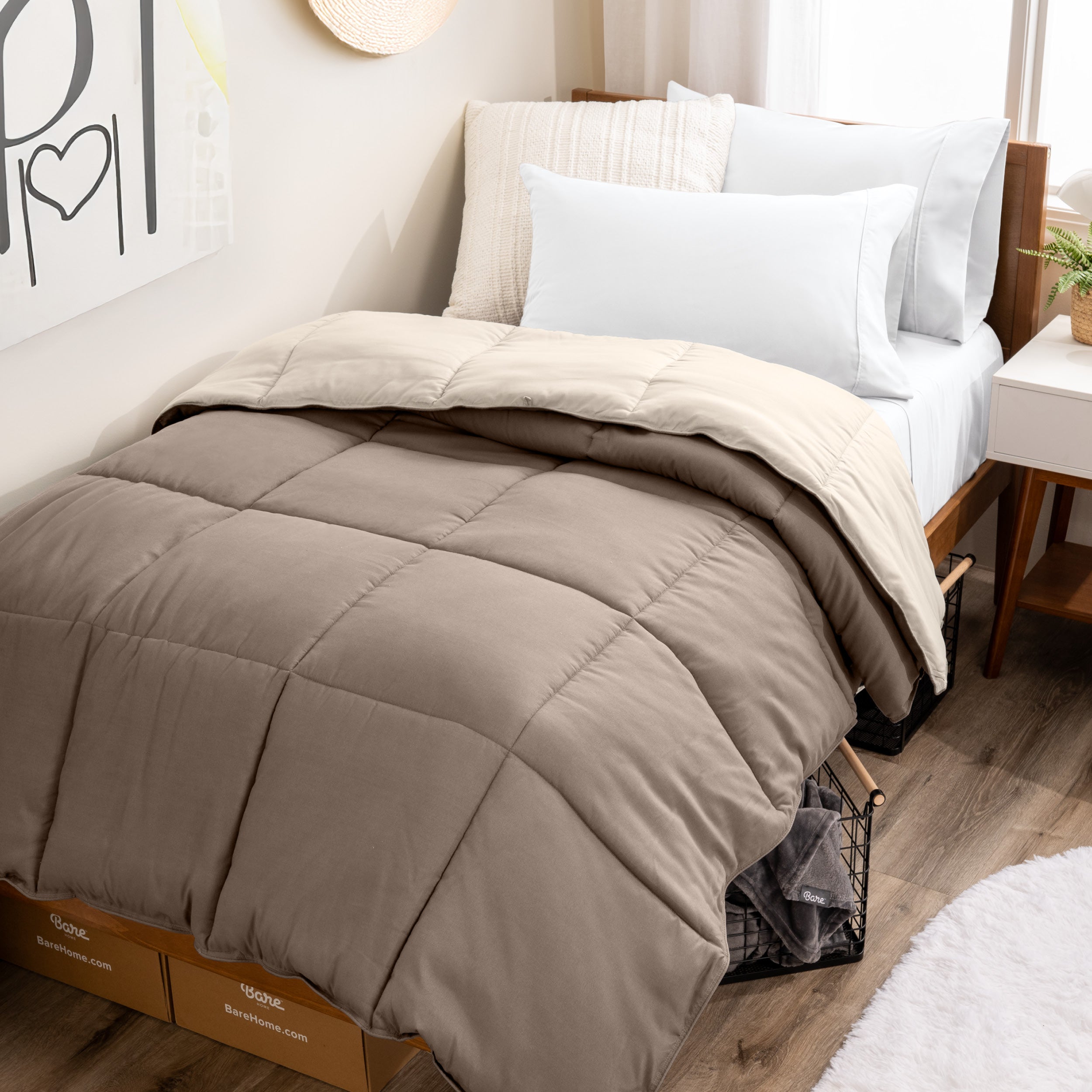 Wooden bed frame with a reversible comforter on the bed. The comforter is folded back over showing the two different colors.