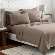 A bedroom setting with a bed made with the microfiber bed sheets and four pillows.
