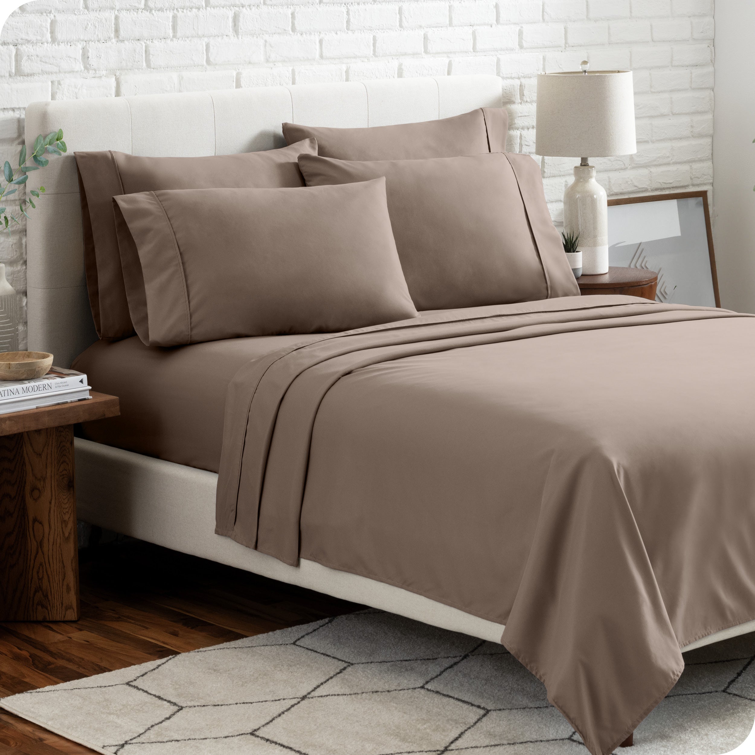 A bedroom setting with a bed made with the microfiber bed sheets and four pillows.