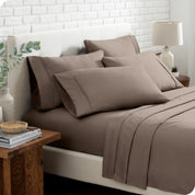Close up of the microfiber bed sheets on a bed with four pillows.