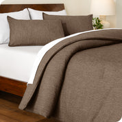 A side view of a bed made with a track stitch comforter set