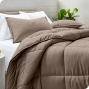 A side view of a modern bed with a comforter set and pillows on the bed