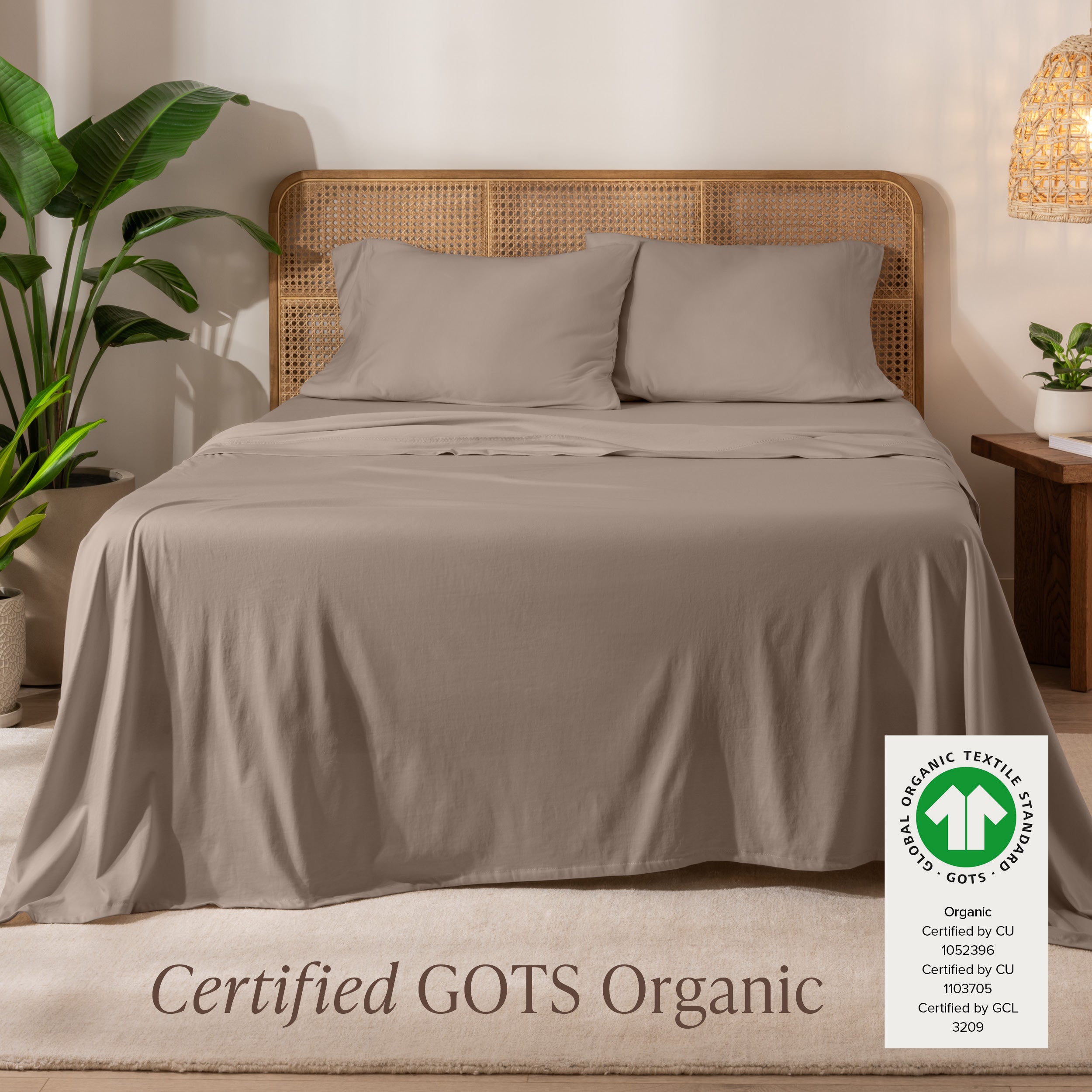 A bed in the middle of room with a set of Certified GOTS Organic Jersey Sheet Set on it.
